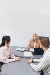 Married couple filing divorce papers in lawyer's office. Statue of Themis close-up in lawyer's office, blurred couple divorce proceedings in background blurred advocate negotiation