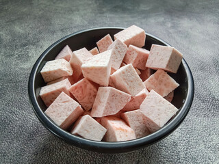 Taro, sliced of taro in a bowl. Fresh taro cubes in a bowl on black background. Food ingredients.