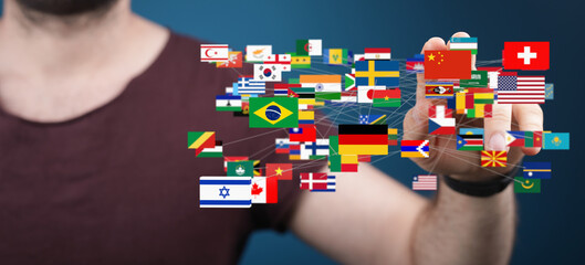 Image of a man interacting with a network of world flags, symbolizing global connection and...