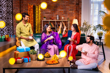Drinking tea during Diwali with Indian relatives and friends at decorated indoor festive home