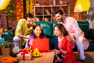 Opening Diwali present from friend and reacting with amazement during festival celebration