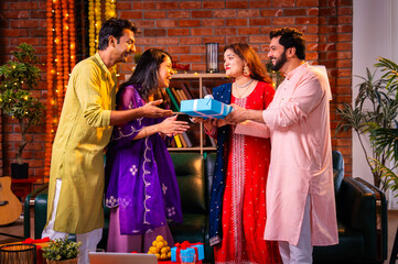 Obraz premium Couple welcomes friends and receives Diwali surprise in traditional dress at decorated home