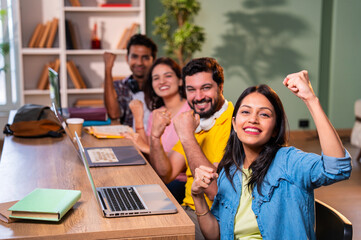 Happy Indian classmates enjoy teamwork moment after finishing group project in college library