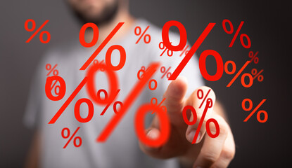 Red percentage symbols floating around a hand, symbolizing discounts, interest rates, or financial...