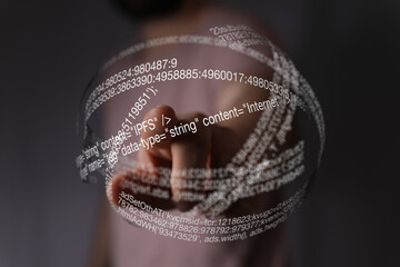 Abstract image of a person interacting with a futuristic holographic display showing lines of code.