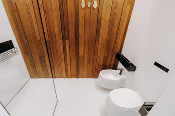 A bathroom equipped with a toilet, sink, and a mirrored surface
