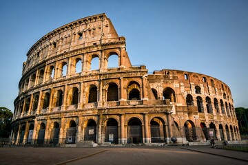 Obraz premium The Colosseum in Rome Illuminated at Sunset with Clear Sky