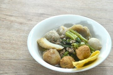 boiled fish ball with dumpling topping shrimp ball and morning glory in clear soup on bowl