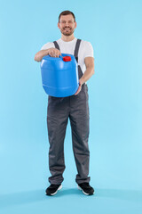 Man holding plastic canister on light blue background