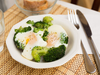 Breakfast of scrambled eggs with broccoli on the table