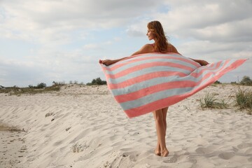 Beautiful woman with beach towel on sand