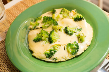 Wholesome breakfast. omelet with broccoli on green plate