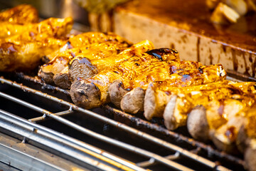 slices of king oyster mushrooms are being charcoal-grilled to a golden brown on a grill