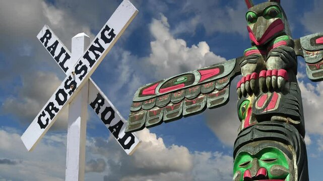 Railroad Crossing sign and First Nation Totem pole, British Columbia , Canada