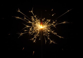 Sparkler emitting bright light and sparks against a dark background