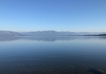 Fototapeta premium Lake wakatipu calm waters reflecting distant mountains under a clear sky
