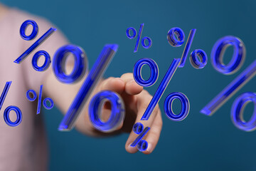 Person's hand interacting with blue percentage symbols. Concept of interest rates, finance, and...