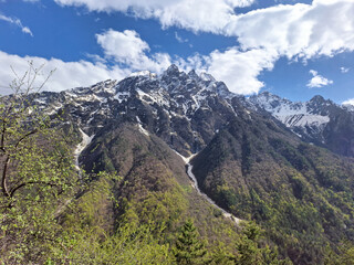 Majestic snow-capped mountains against a blue sky with clouds  