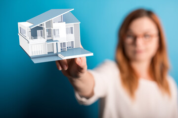 Woman showcasing a digital 3D model of a modern house. Ideal for real estate, architecture, and...