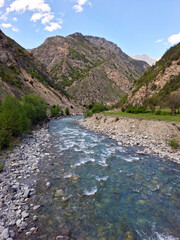 Scenic river winding through mountains under a clear blue sky  