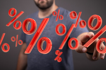 Red percentage symbols floating around a man's hand. Concept for discounts, sales, interest rates,...