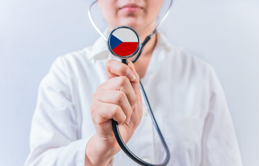 Female doctor holding stethoscope with Czech Republic flag. National health system of Czech Republic