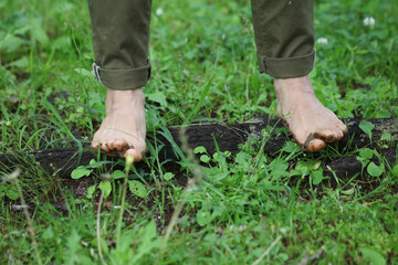 裸足で木の根に乗る女性