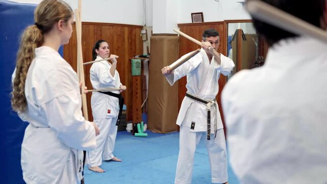 Martial arts master demonstrating jo staff techniques to students