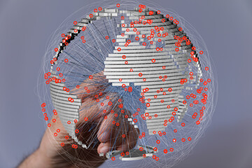 A hand interacts with a 3D model of Earth, showcasing interconnected data points across the globe.