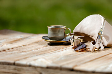 Spring or summer composition with female stuff on wooden garden table with natural outdoor green...