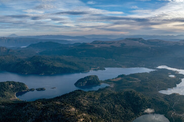 Obraz premium Scenic aerial view of Lake Alumine with forested hills dotted with Araucaria trees under cloudy sky in Patagonia. Neuquen, Patagonia Argentina