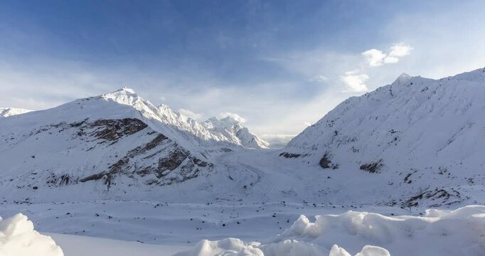 4k timelapse video of Panoramic winter view of Drang Drung Glacier in Zanskar Valley, Ladakh, surrounded by snow-covered Himalayan peaks and blue sky