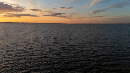 Serene sunset over calm waters reflecting vibrant colors at a tranquil lakeside