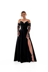 Fototapeta premium Elegant woman poses confidently in a stunning black evening gown with sparkling details and stylish gloves