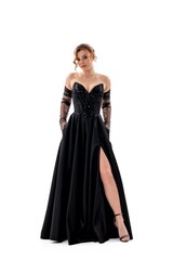 Naklejka premium Elegant female model showcases black evening gown with sparkling details and high slit in a minimalist setting
