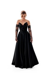 Elegant woman in a black evening gown posing gracefully against a neutral background