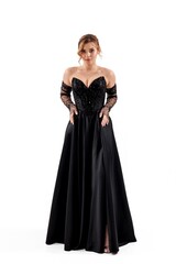 Fototapeta premium Elegant woman in black evening gown posing against a white background showcasing fashion and style at a formal event