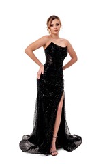 Elegant woman poses in a stunning black gown with shimmering details and a stylish slit for a...