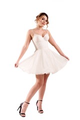 Elegant woman in white dress poses gracefully on a white background showcasing fashion and style...