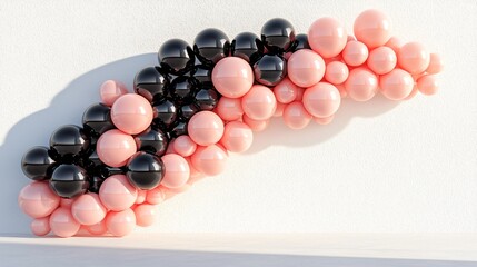 modern balloon arch combining glossy black and blush pink balloons, displayed near a clean stucco wall with textured finish, white floor with gentle shadow gradient