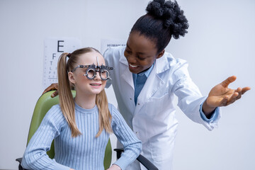 African american female optometrist checking vision of a small patient