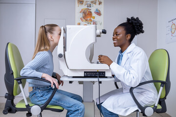 Doctor checking vision of a girl by using medical equipment