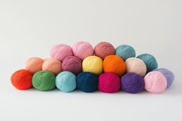 A pile of balls of yarn in various colors on a white background, showcasing the variety and beauty of different threads for knitting or crocheting.