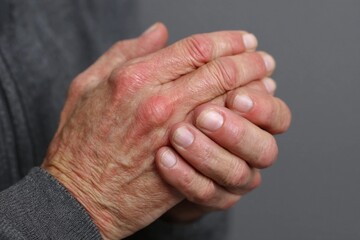 Fototapeta premium Elderly hands clasped together in contemplation, conveying wisdom and experience