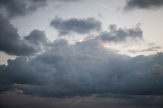 dramatic grey and black storm clouds rolling in sky over horizon and ocean