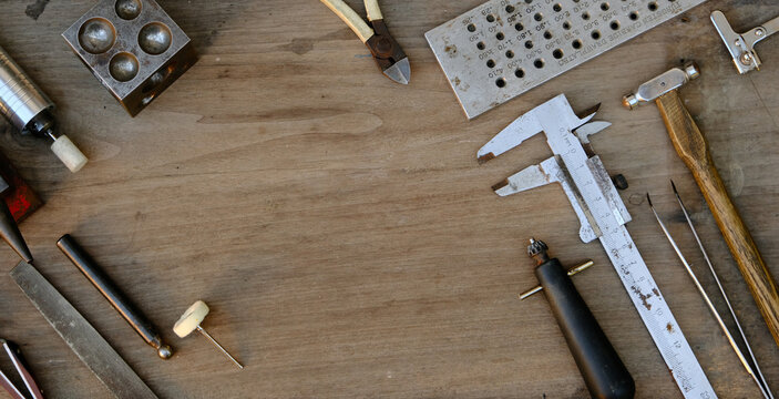 Jeweler's workplace. Top view of jeweler's workbenche with different tools on a wooden table. Goldsmith concept background