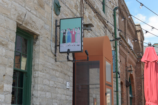 exterior building facade and projecting sign of Madrina Bar y Tapas, a Spanish-Catalan restaurant located in the Distillery District at 2 Trinity St, Toronto