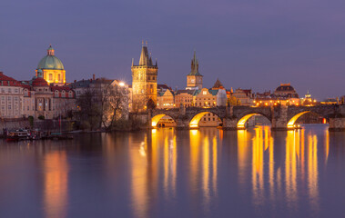 Illuminated Charles Bridge over the Vltava River at sunset in Prague Czech Republic