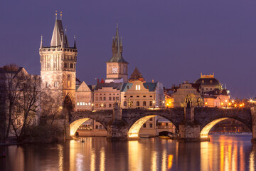 Illuminated Charles Bridge over the Vltava River at sunset in Prague Czech Republic