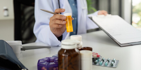 Doctor Holding Prescription Bottle and Reviewing Medication